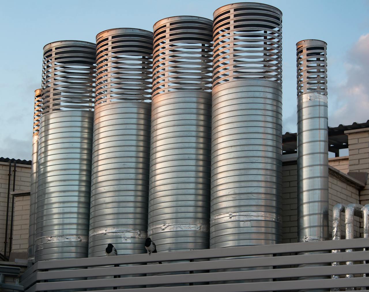Close-up view of industrial steel silos with a clear sky background.