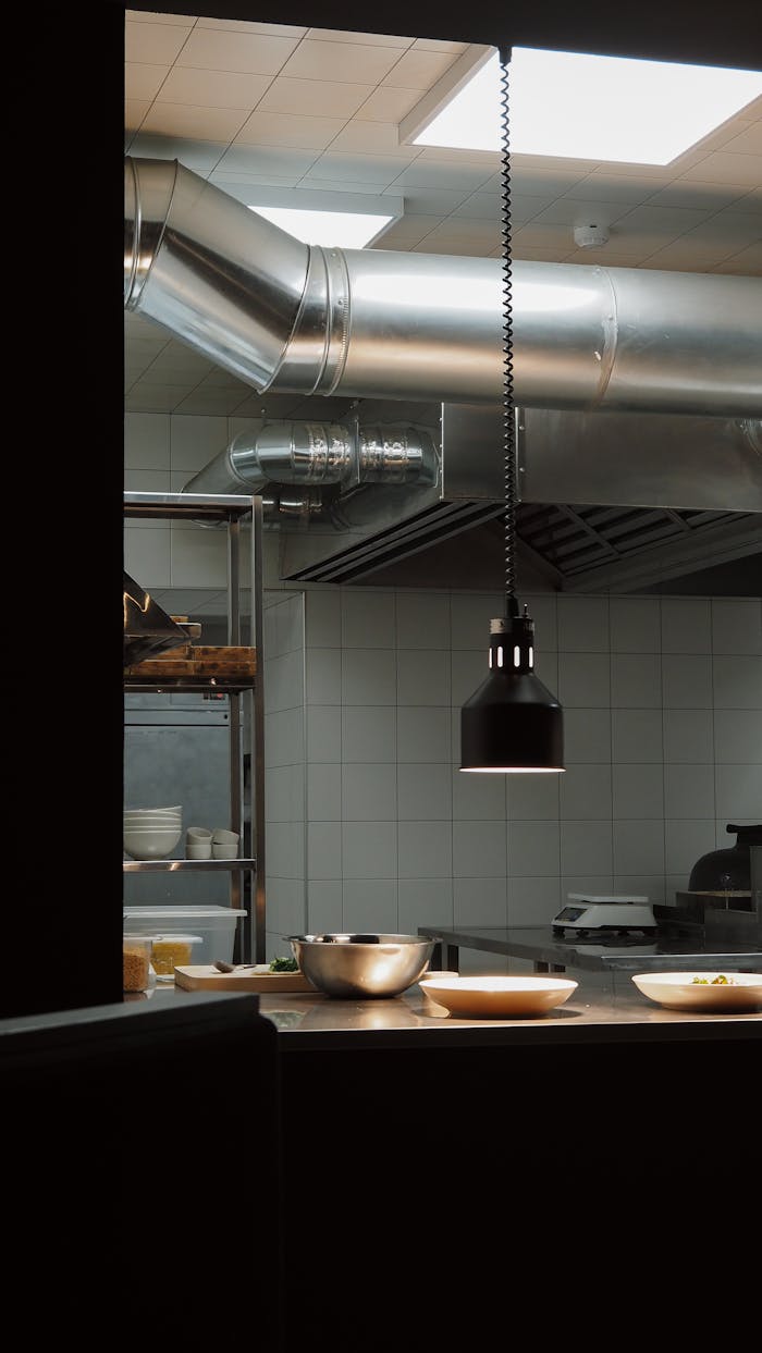 Stylish industrial kitchen setup with overhead lighting and modern fixtures.